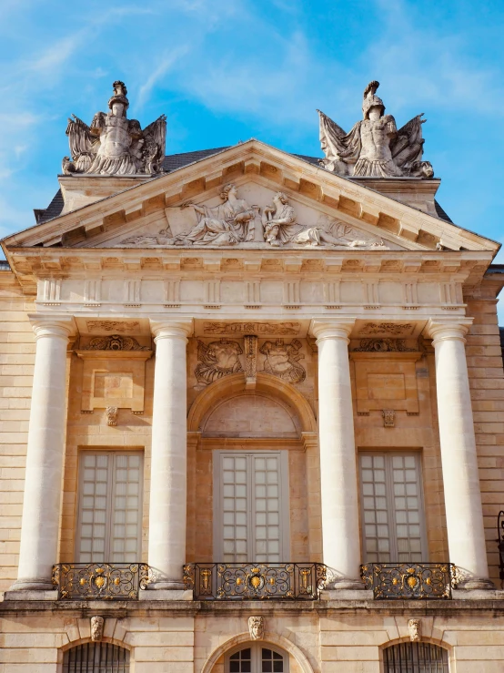 a large building with statues and windows sitting on the outside of it