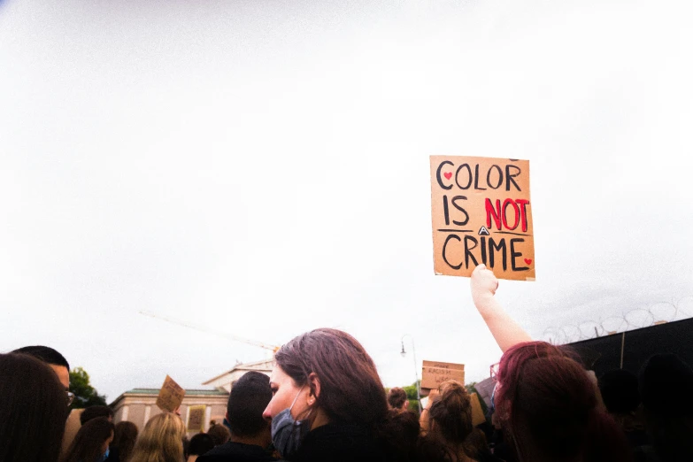 a crowd of people are gathered together with some holding signs