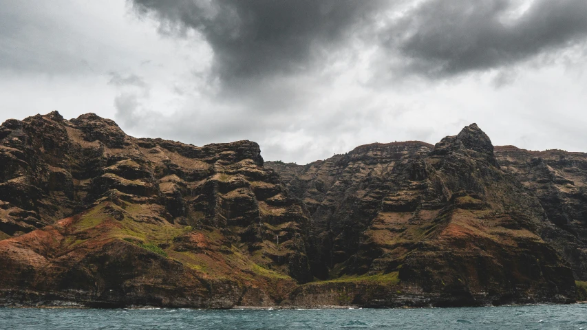 an island in the middle of a body of water with mountains on either side