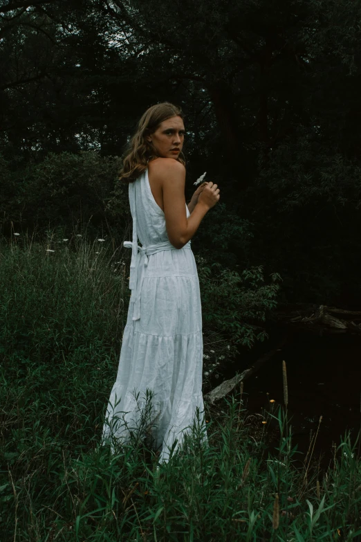 a woman with sunglasses smoking while walking through a field