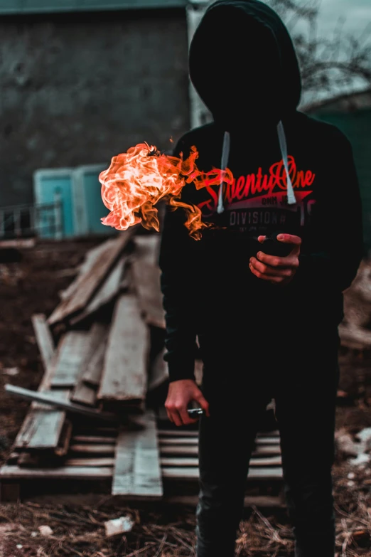 a person is standing outside with flames in his hands