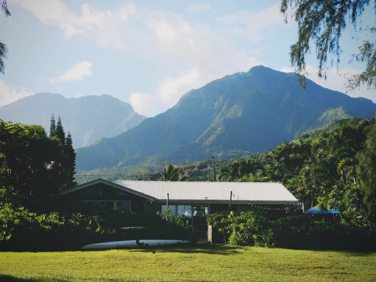 a house in a field in front of a mountain