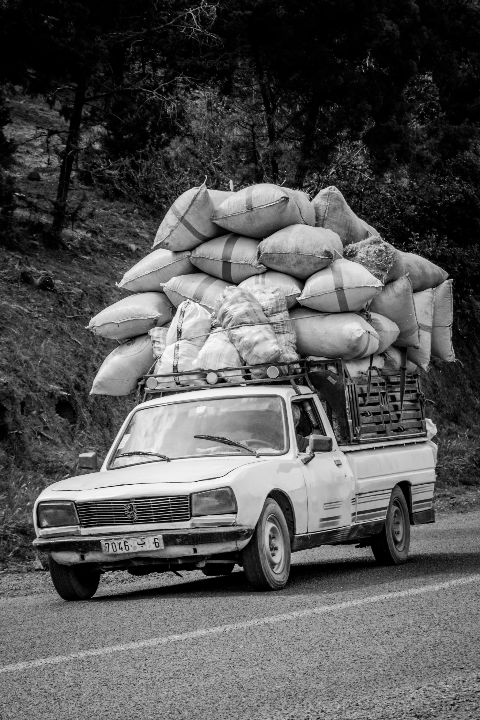 the pick up truck loaded with bags is parked in the road