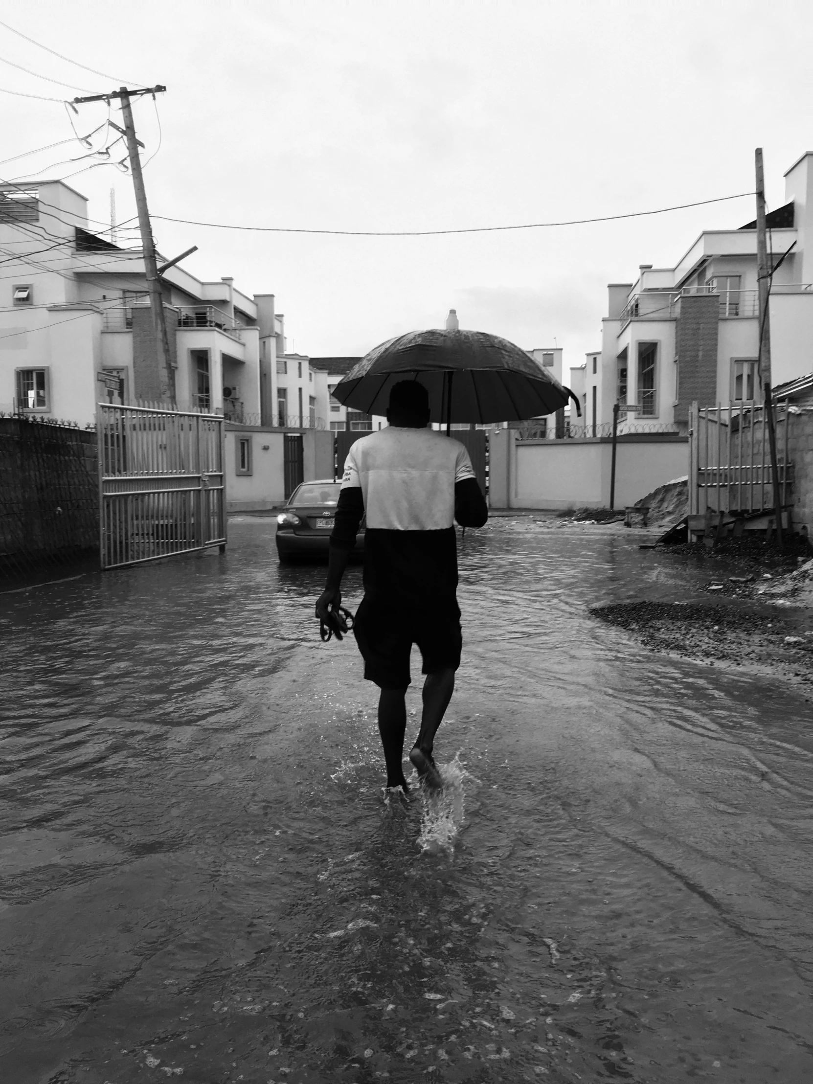 a man walking down the street holding an umbrella