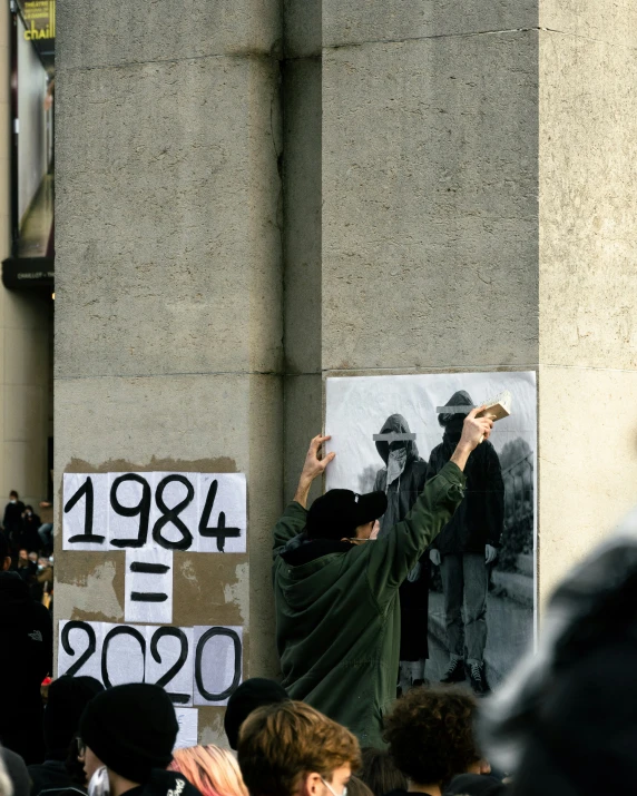 a man reaching high in the air while holding up a peace sign