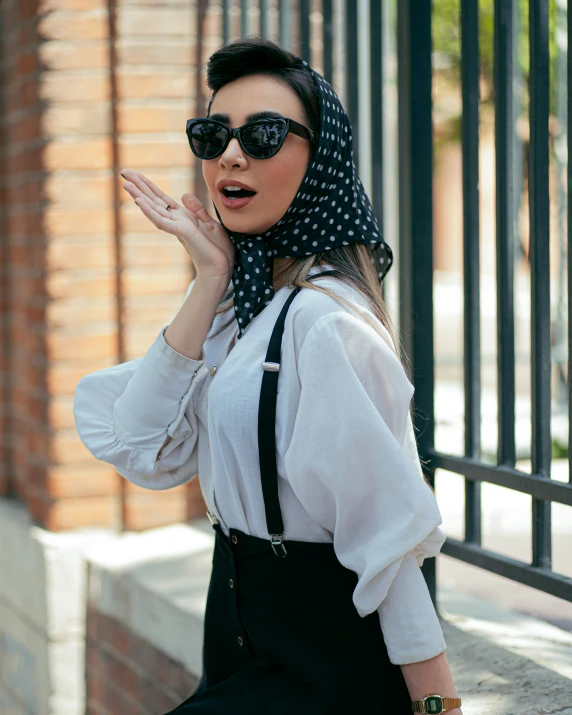 a young woman wearing sun glasses and a bandanna headscarf