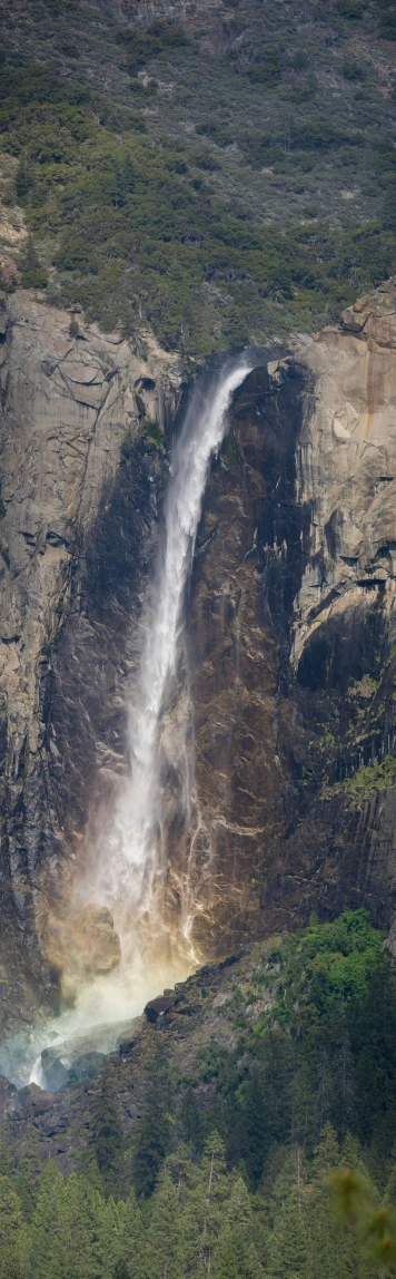 the water flows into a mountain next to a large waterfall