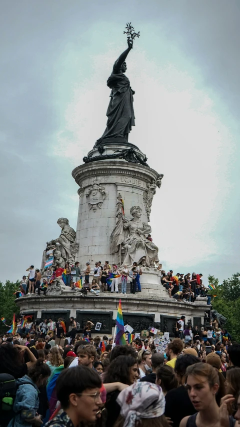 the crowd at the parade is taking pictures in front of the statue