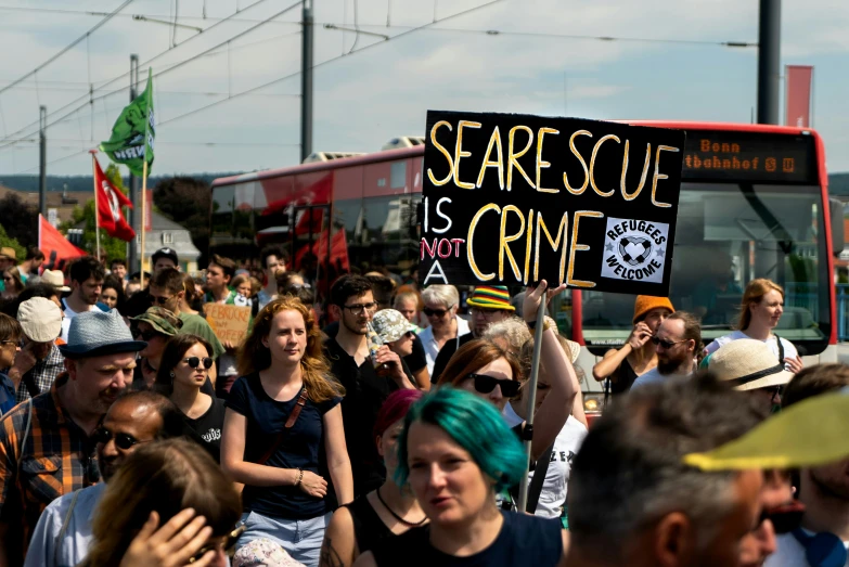 a bunch of people standing around together holding signs