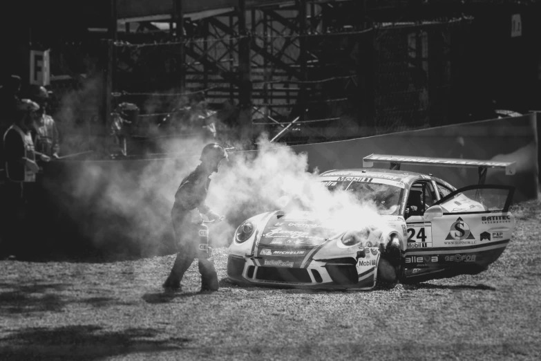 black and white image of car exploding tires at track