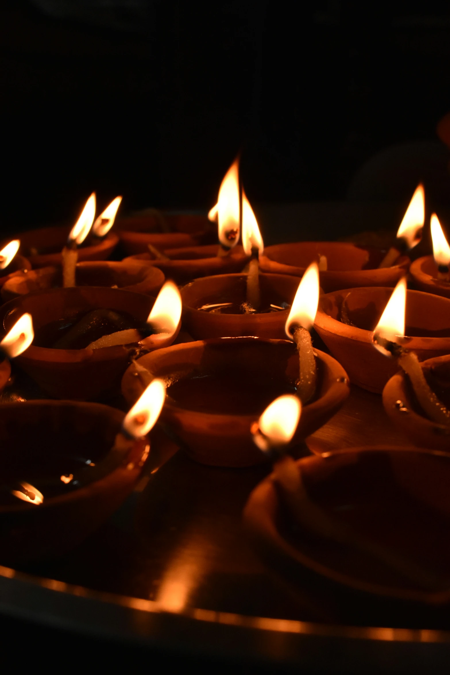 many lit candles glowing red on the table