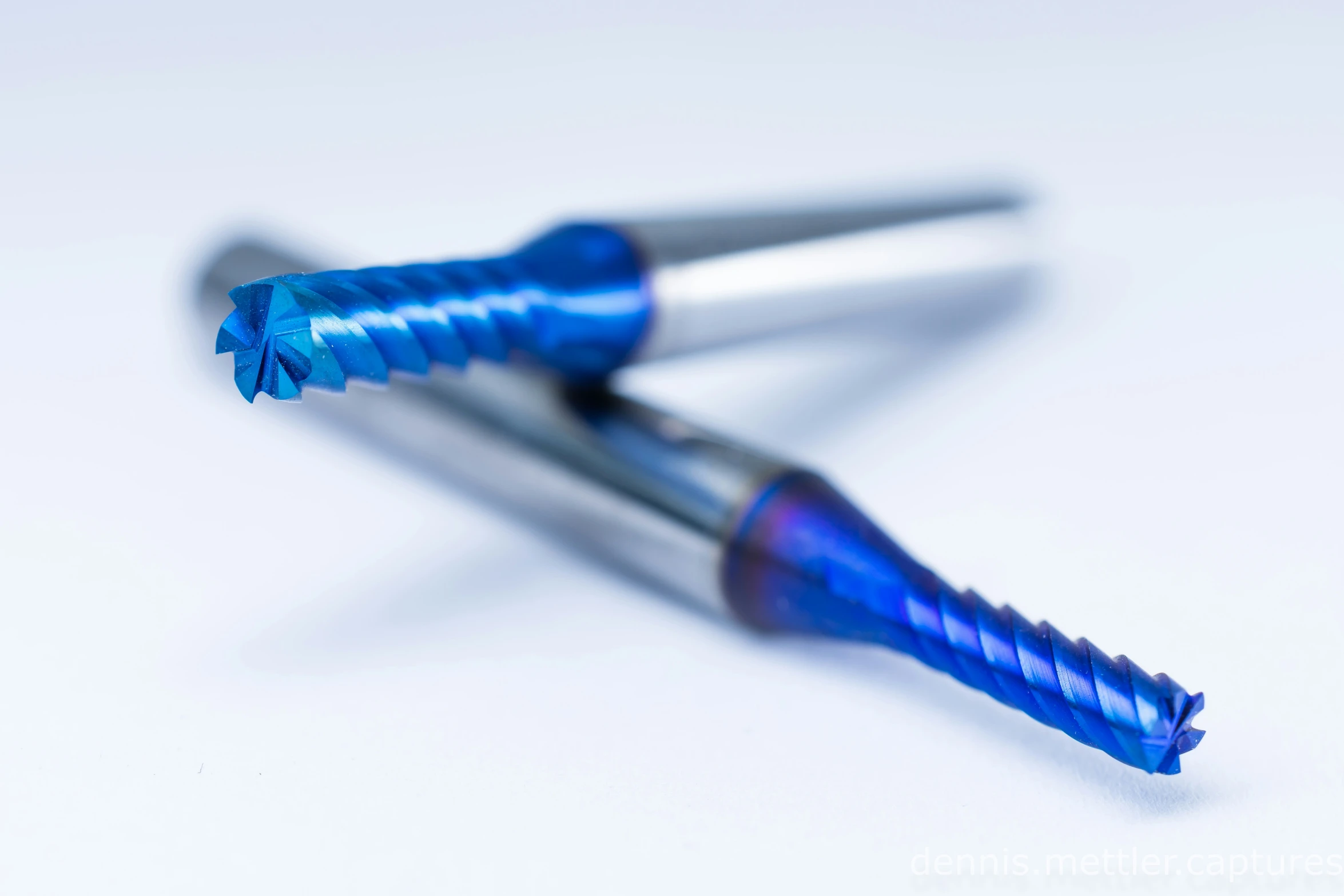 a pair of metal round toothbrushes on top of each other