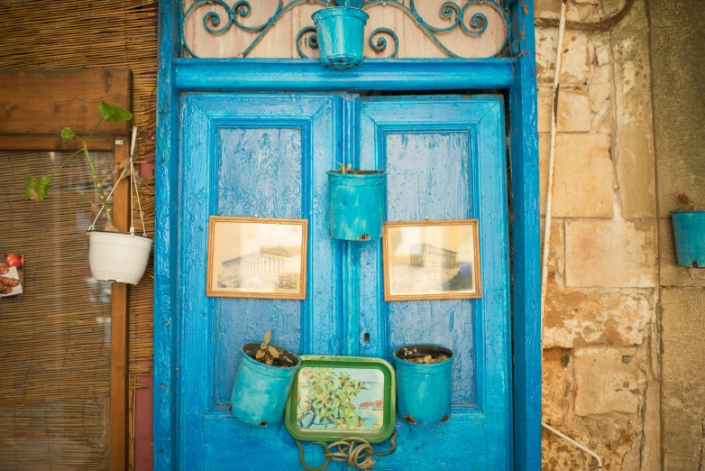 an entrance to a stone building with a blue door and planters