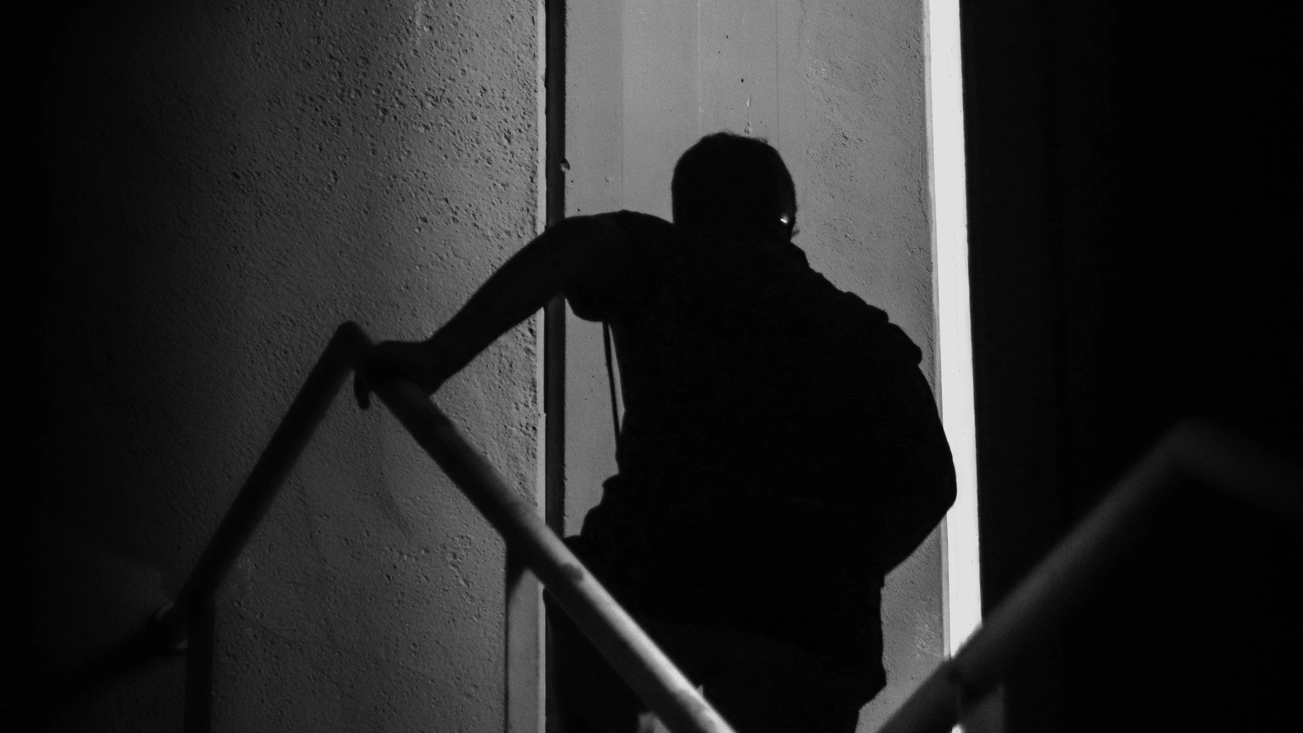 a man is walking along the wall and up to stairs