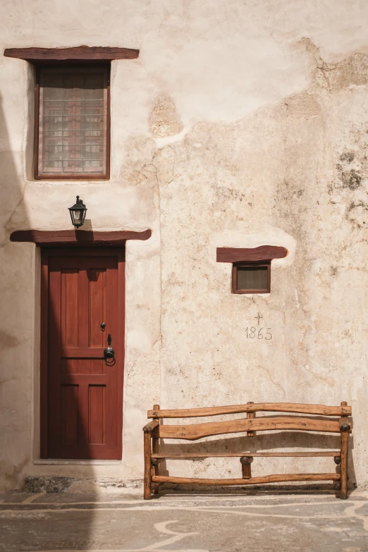 a chair and a door are against the stucco building