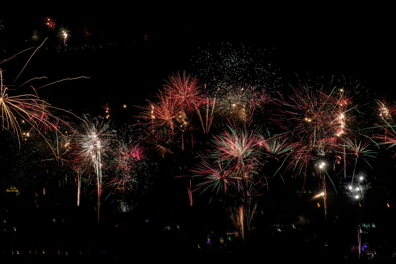 fireworks explode over a city skyline in the dark