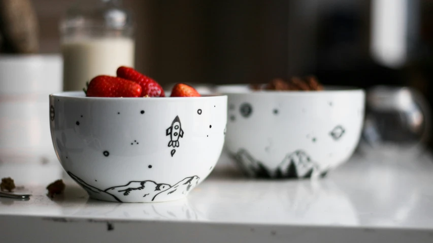 a few white bowls with strawberries in them