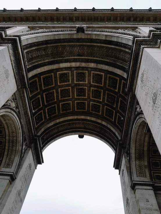 a large arch is above a sidewalk