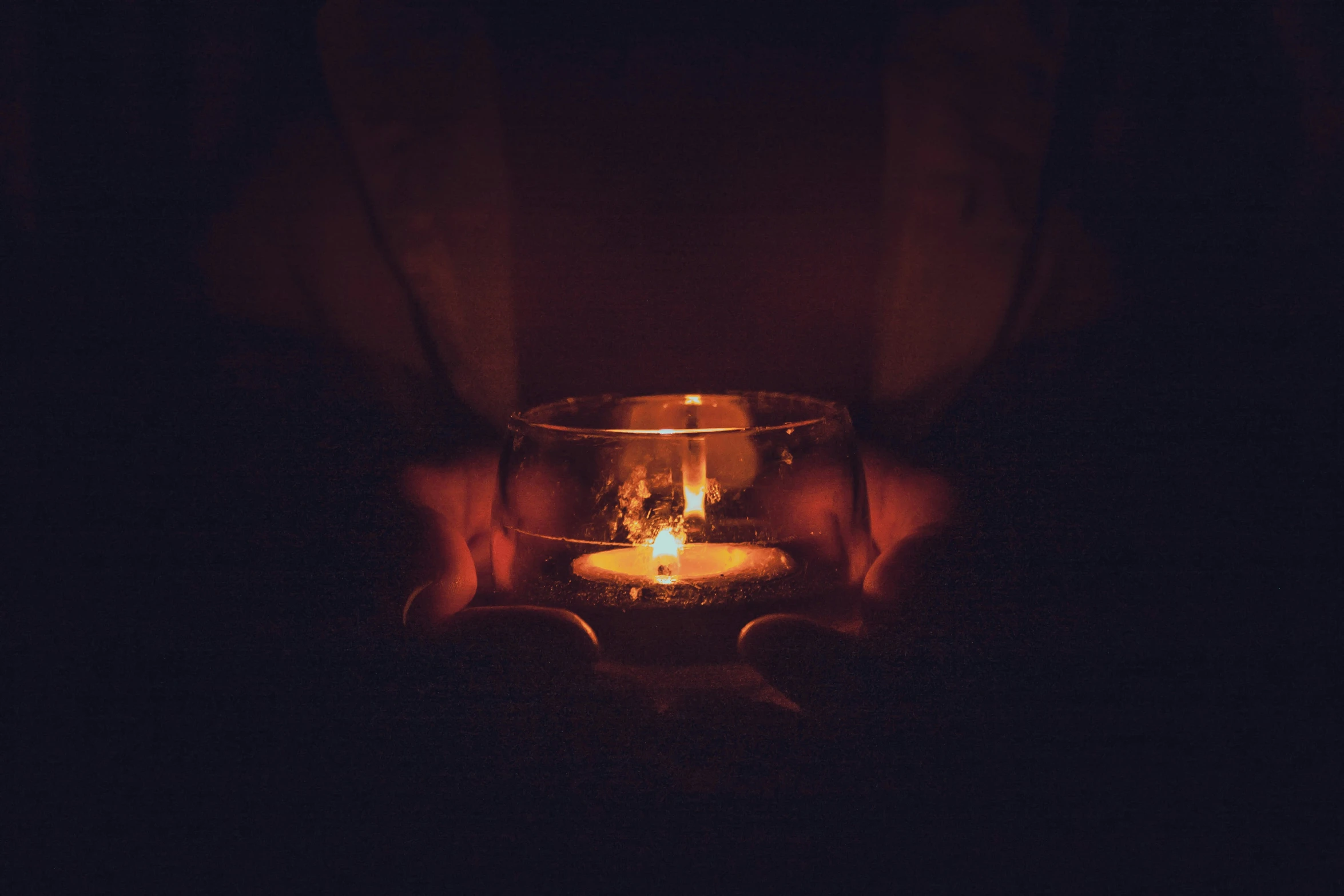 a person's hand holding out their hands as they light a candle