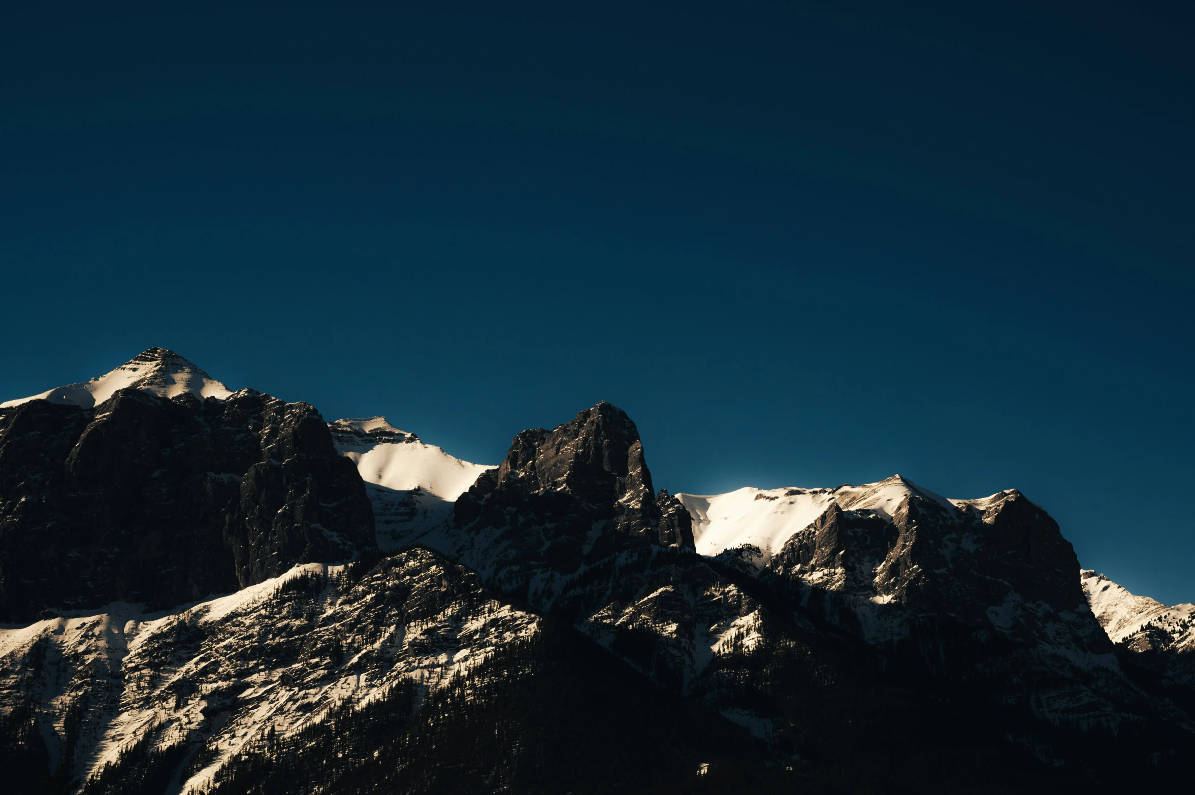 mountains with snow against a blue sky background