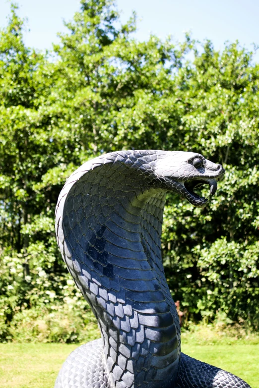 an intricate metal snake statue in the grass