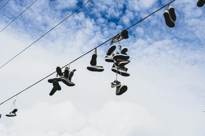 several pairs of shoes hanging from a line