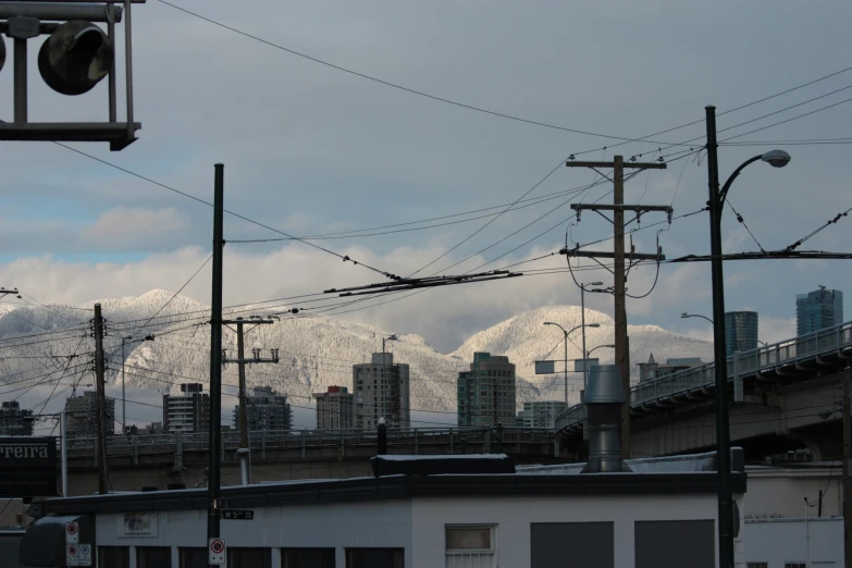 wires, and street lights with snow capped mountains behind them