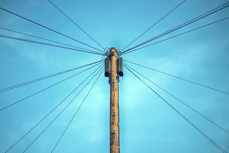 a tall wooden pole with electrical wires above it