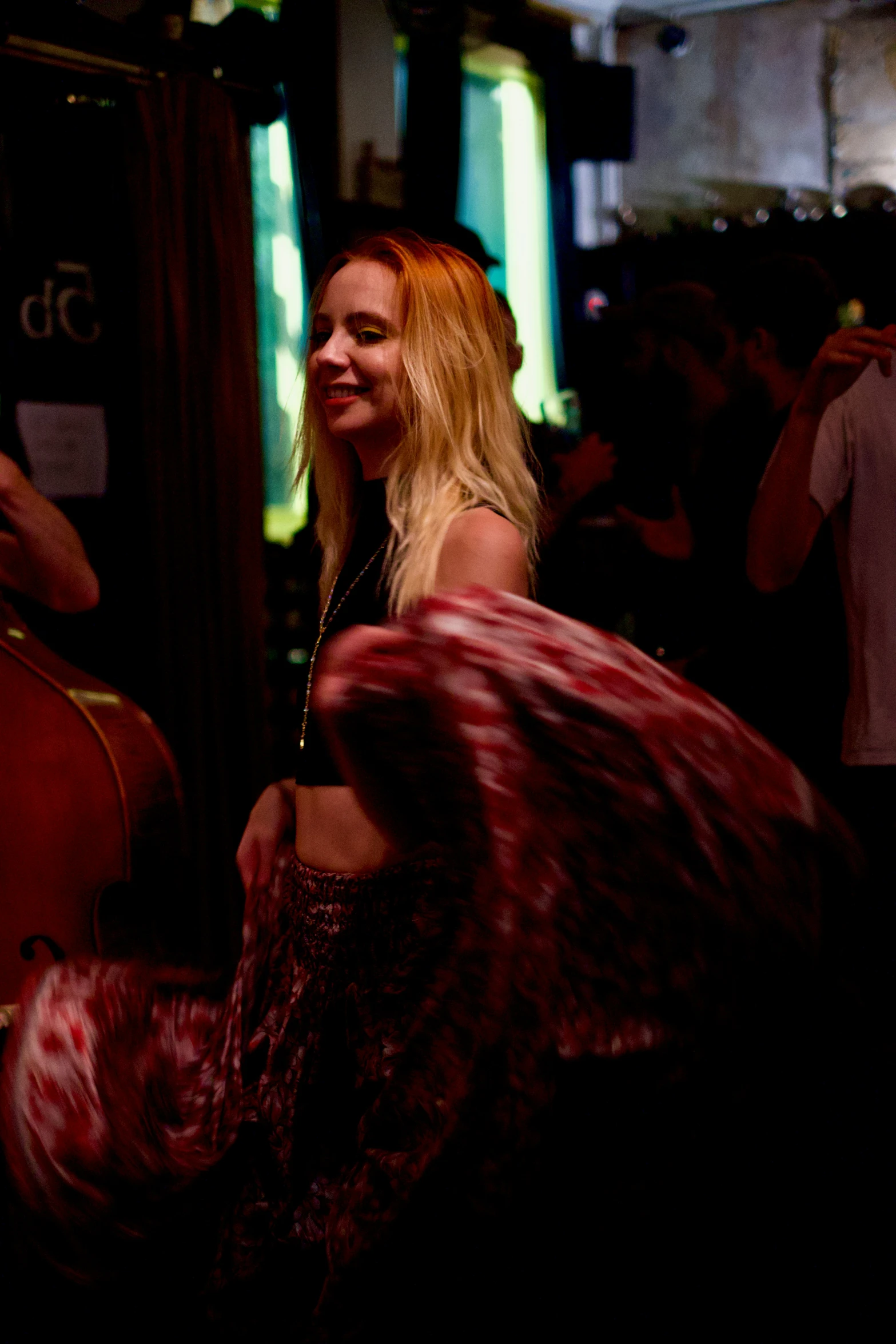 people gathered at the bar looking up at one woman with her back turned