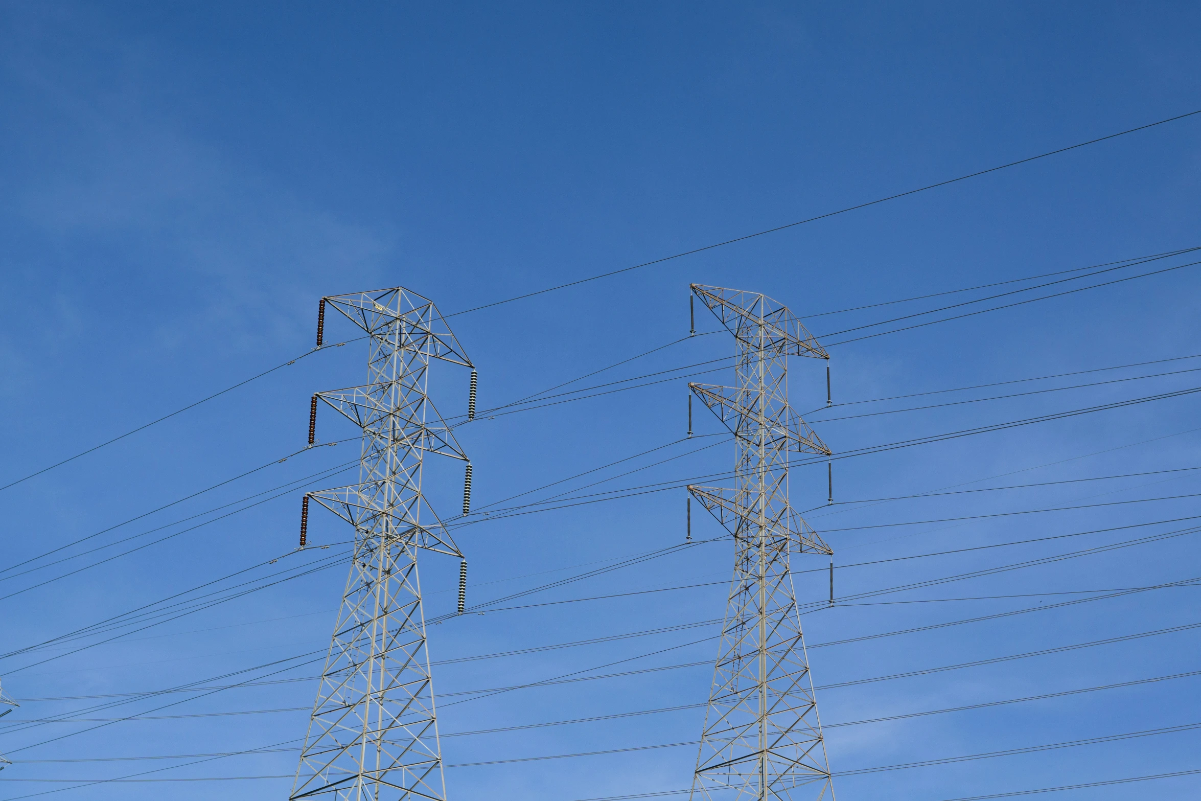 four tall electrical towers are near the sky