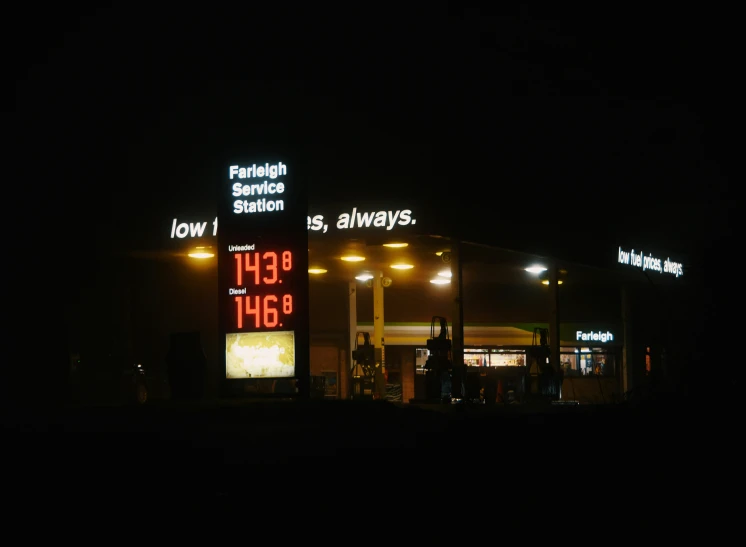 gas pumps lit up with some bright lights at night