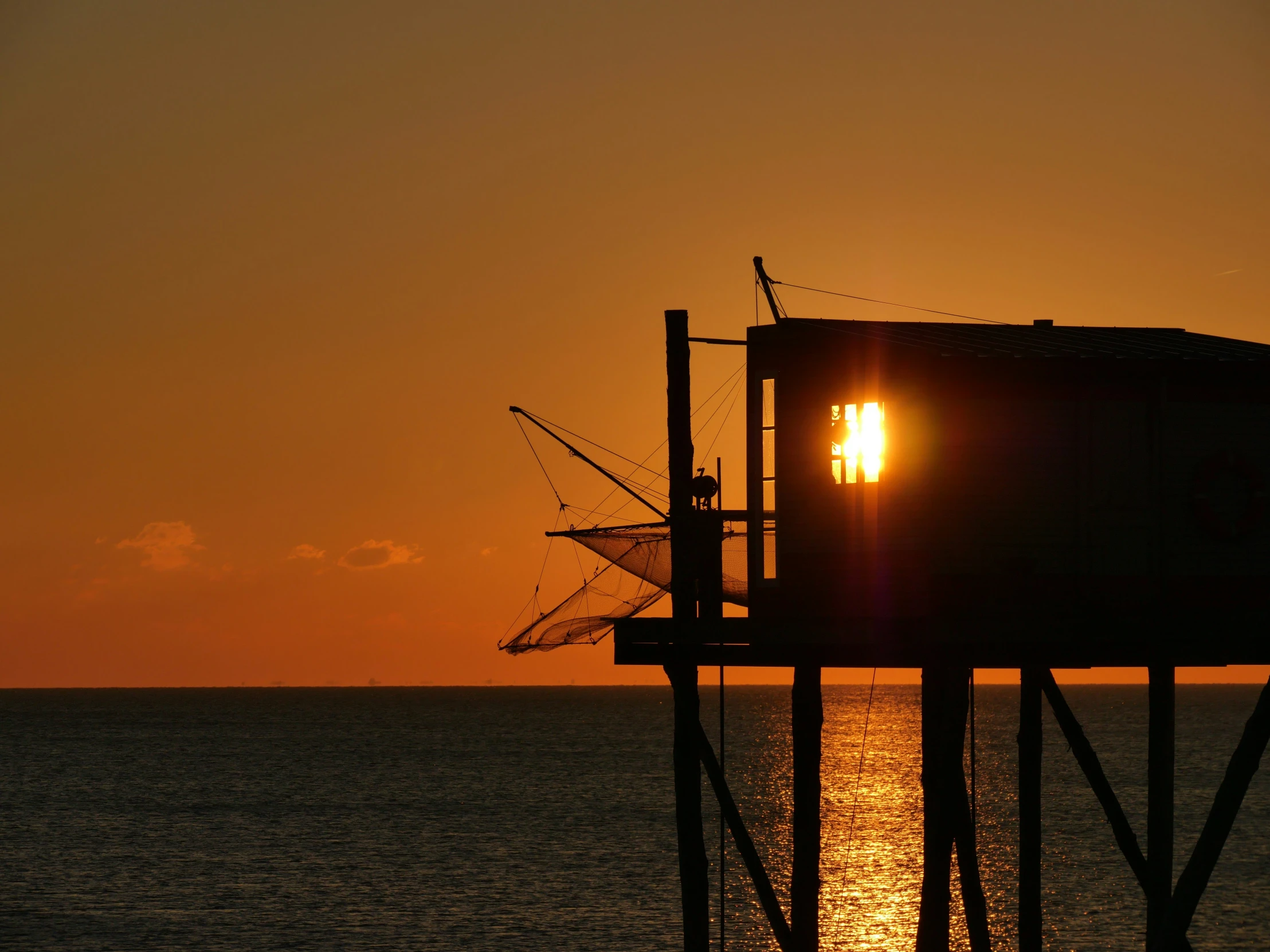 a very tall structure with the sun in the background