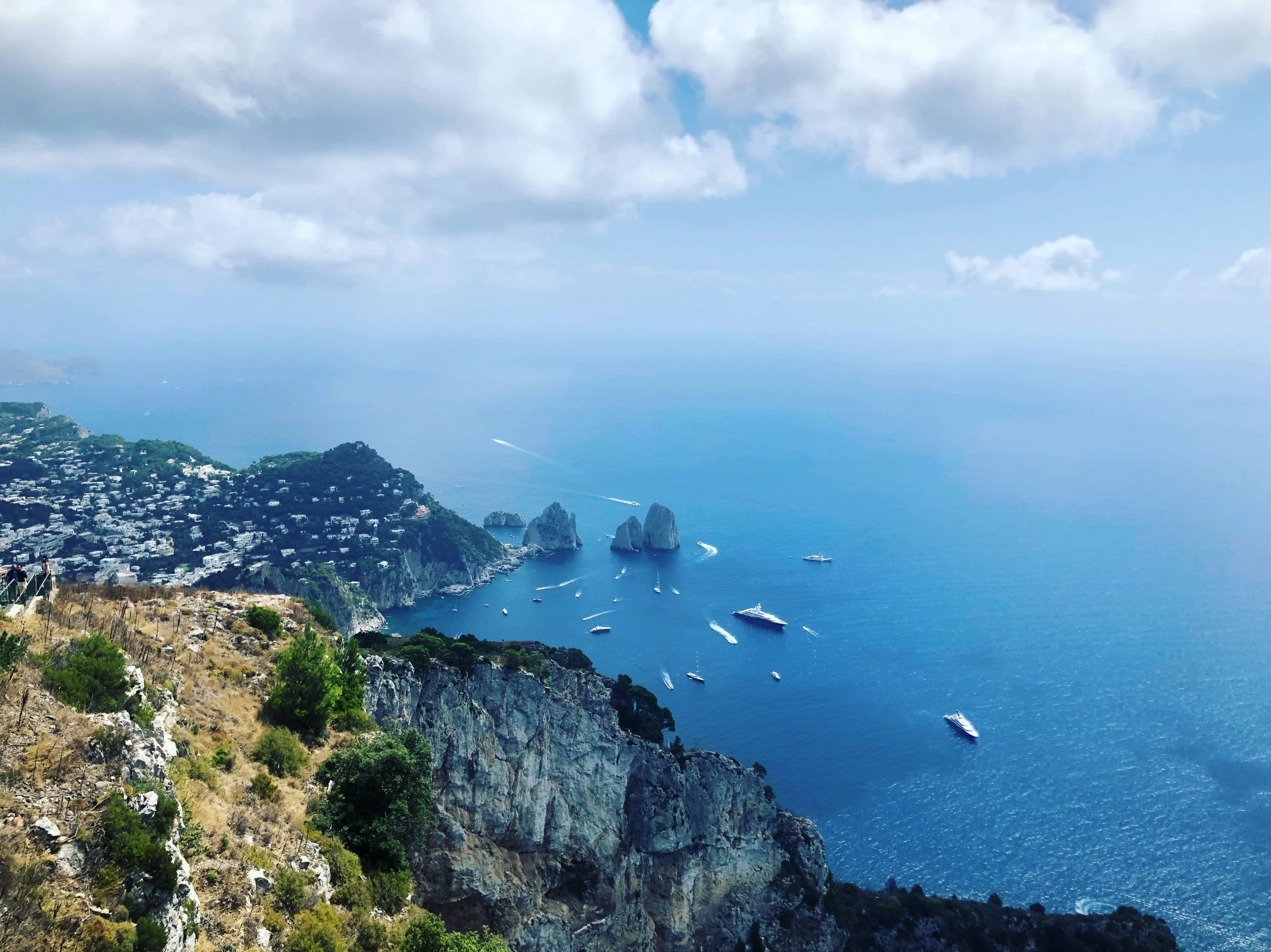 boats on the ocean by the cliffs during the day