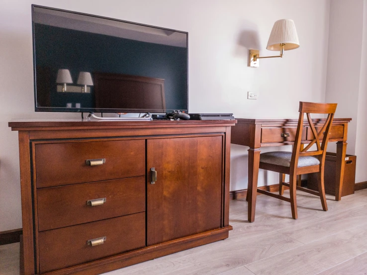 a flat screen television sitting on top of a wooden dresser