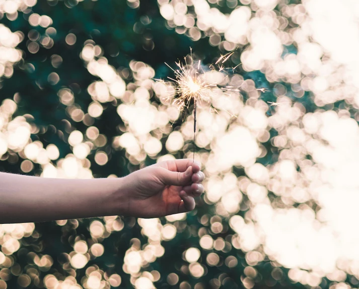 a person holding a small sparkler in their hand