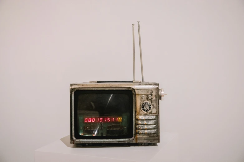 an old - fashioned television sits in a studio, with a broken antenna