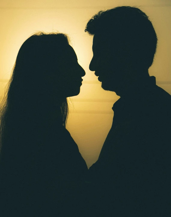 silhouette of a man and woman with the sun setting in the background