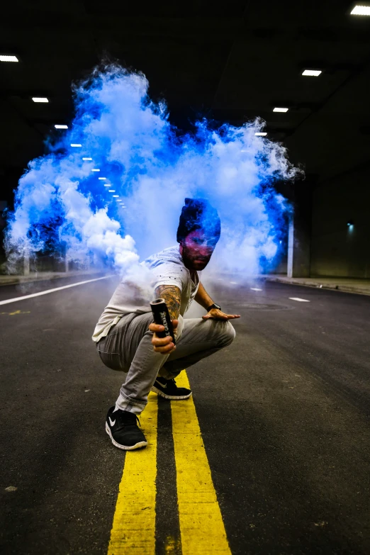 a man on a skateboard rides by blue smoke