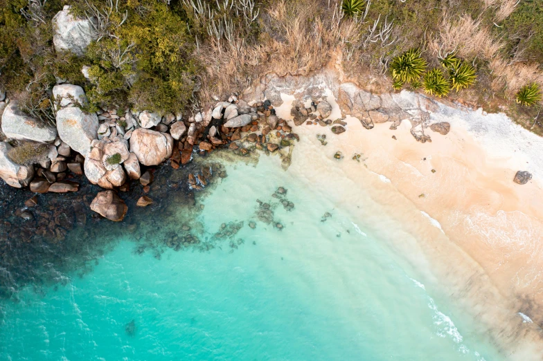 an aerial view shows the beach and rocks