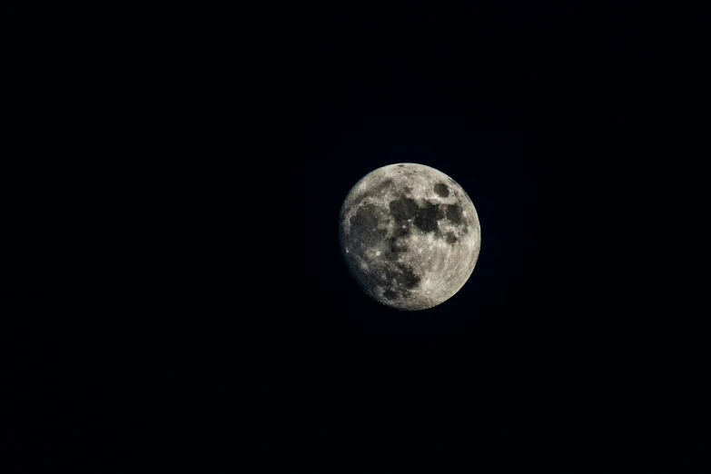 a moon in the sky is black and cloudy