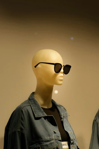 a mannequin wearing a blue denim jacket and black sunglasses