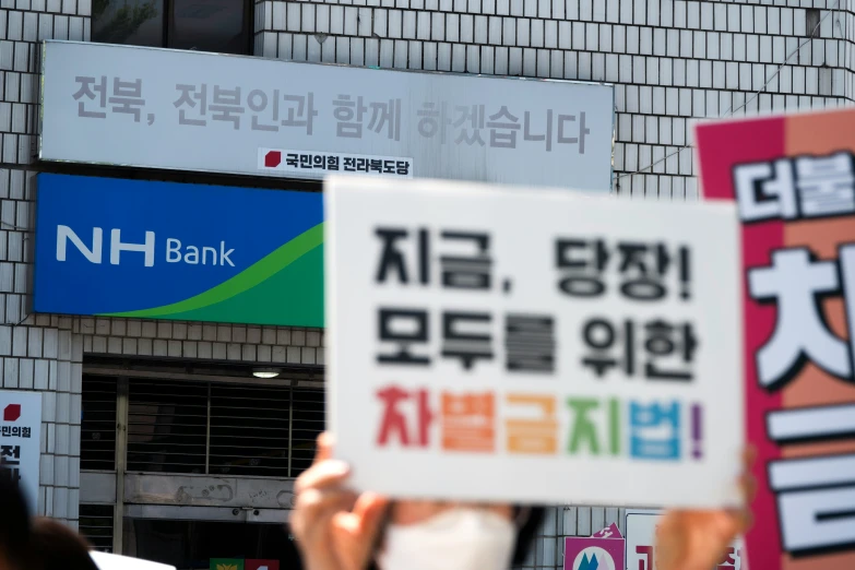 a person holding up a sign with words on it