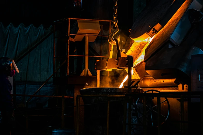 person using a large blow torch in a metal factory