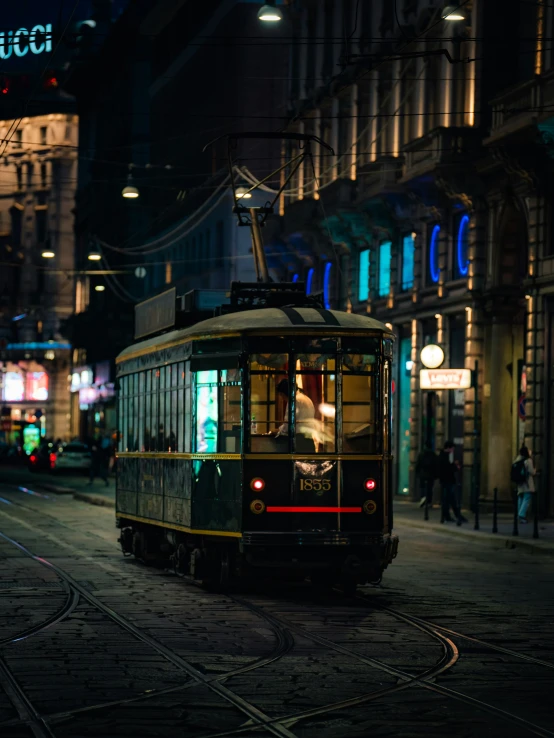 a trolley is driving down a city street at night