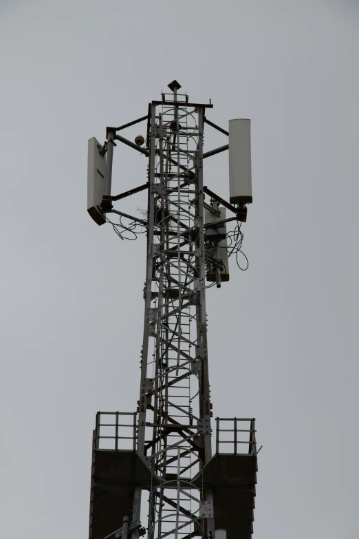 there is an outdoor cellular tower with two antennas attached