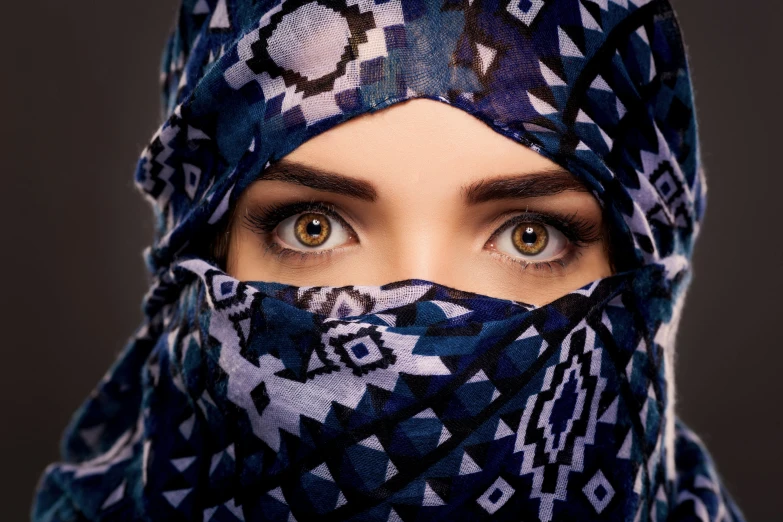 a beautiful young woman wearing a blue, patterned head scarf
