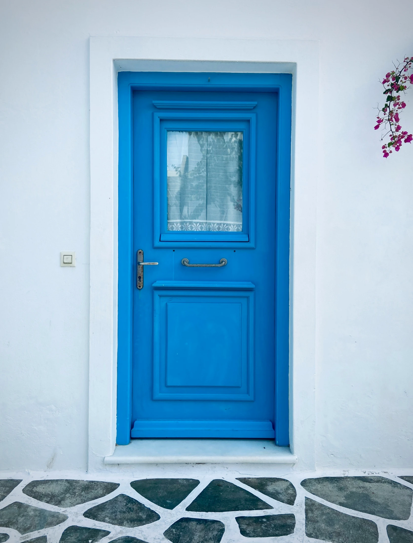 blue front door with decorative floor on house