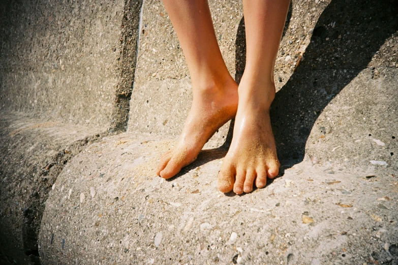 a person has their bare feet in the sand