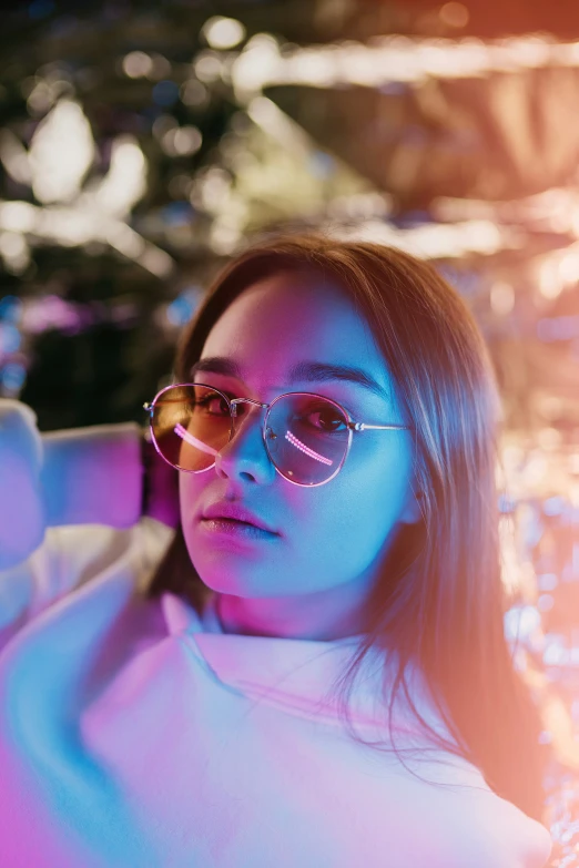 a woman wearing sunglasses in a neon lit area