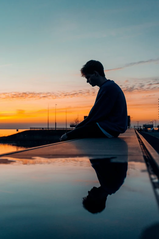 the man sitting on the surface of water in the evening